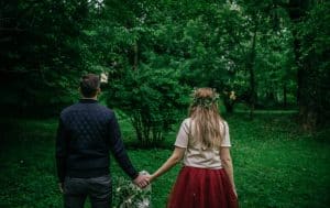 Man and woman back to back holding hands