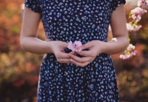 Mujer sosteniendo flores pequeñas